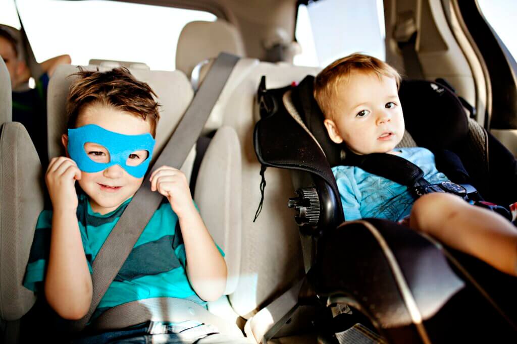 boy eating pizza and wearing a super hero mask